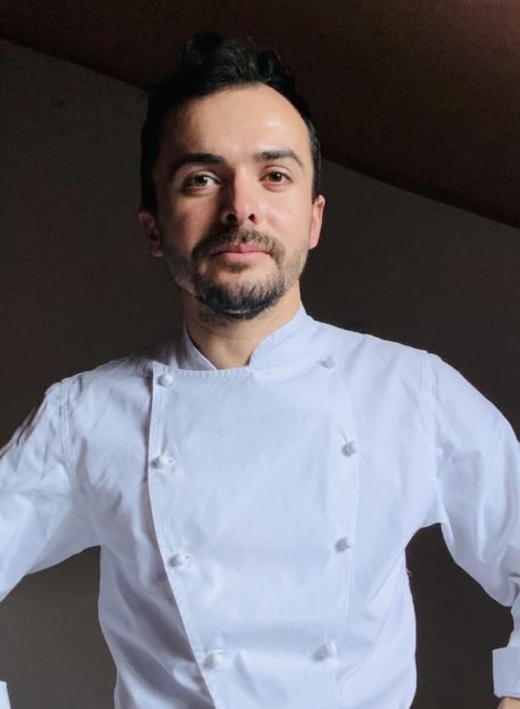 Ritratto dello chef Fatjon Geri in giacca bianca